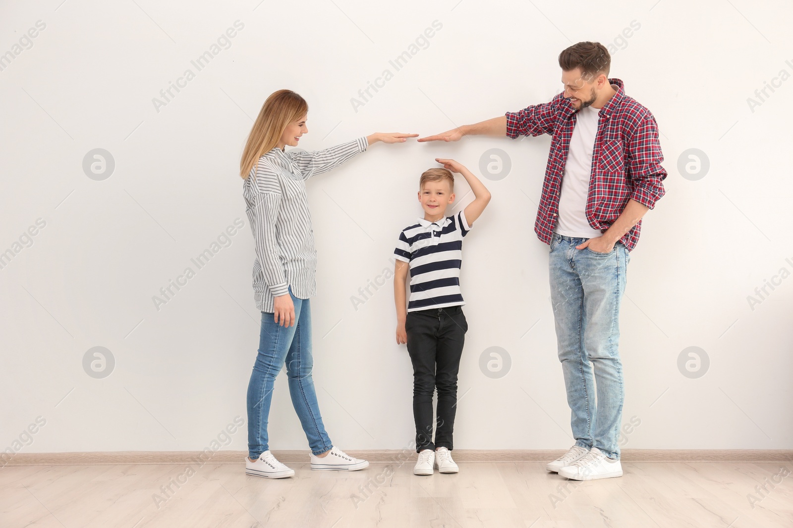 Photo of Parents measuring their son's height indoors