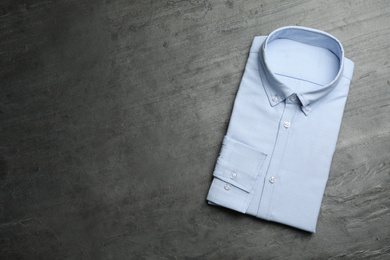 Photo of Male stylish light blue shirt on grey stone background, top view. Space for text