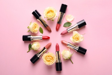 Photo of Flat lay composition with lipsticks and roses on color background