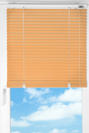 Window with modern orange blinds, closeup view