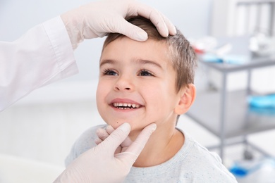 Photo of Dermatologist examining little boy's birthmark in clinic