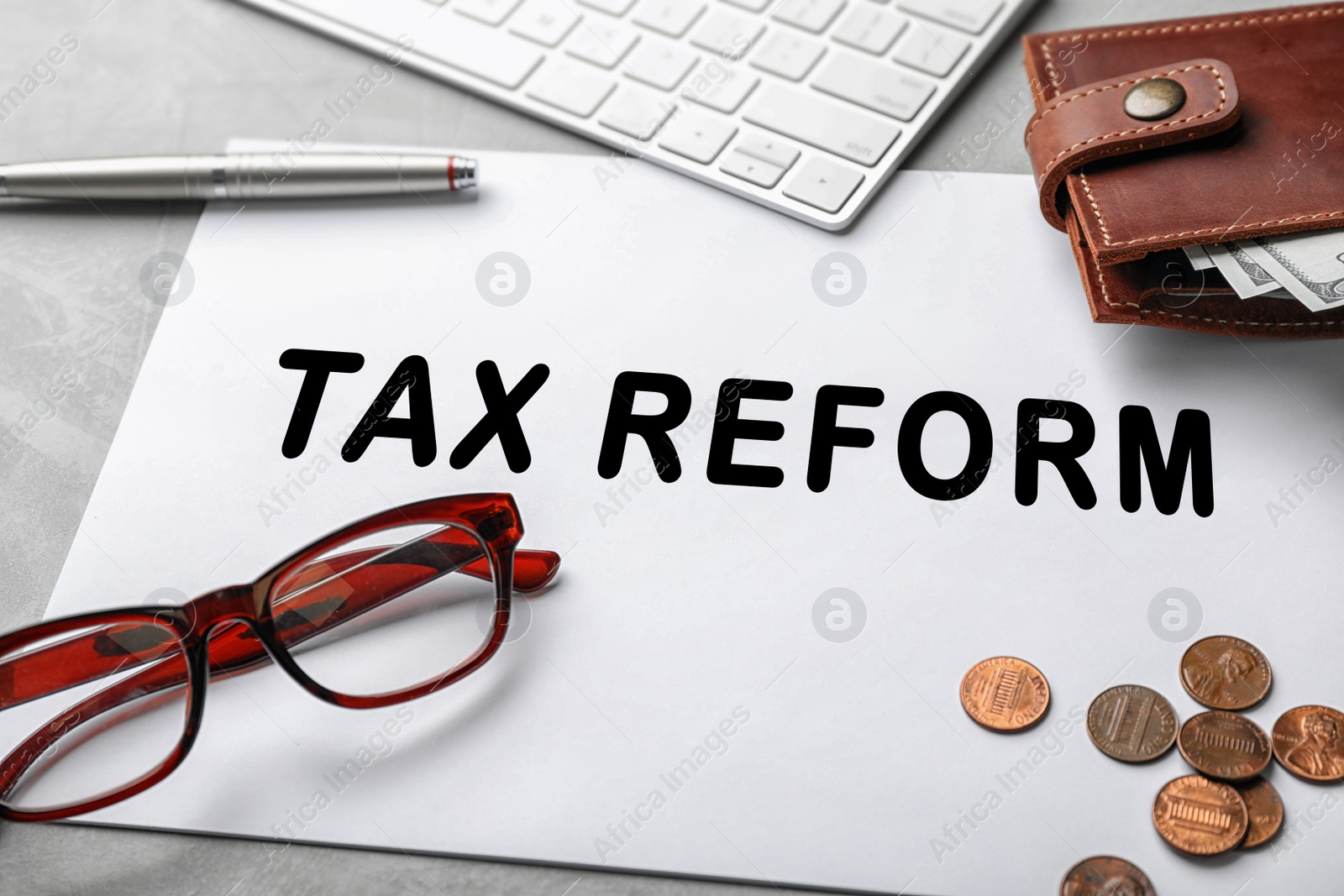 Image of Composition of paper with words TAX REFORM, glasses and money on table