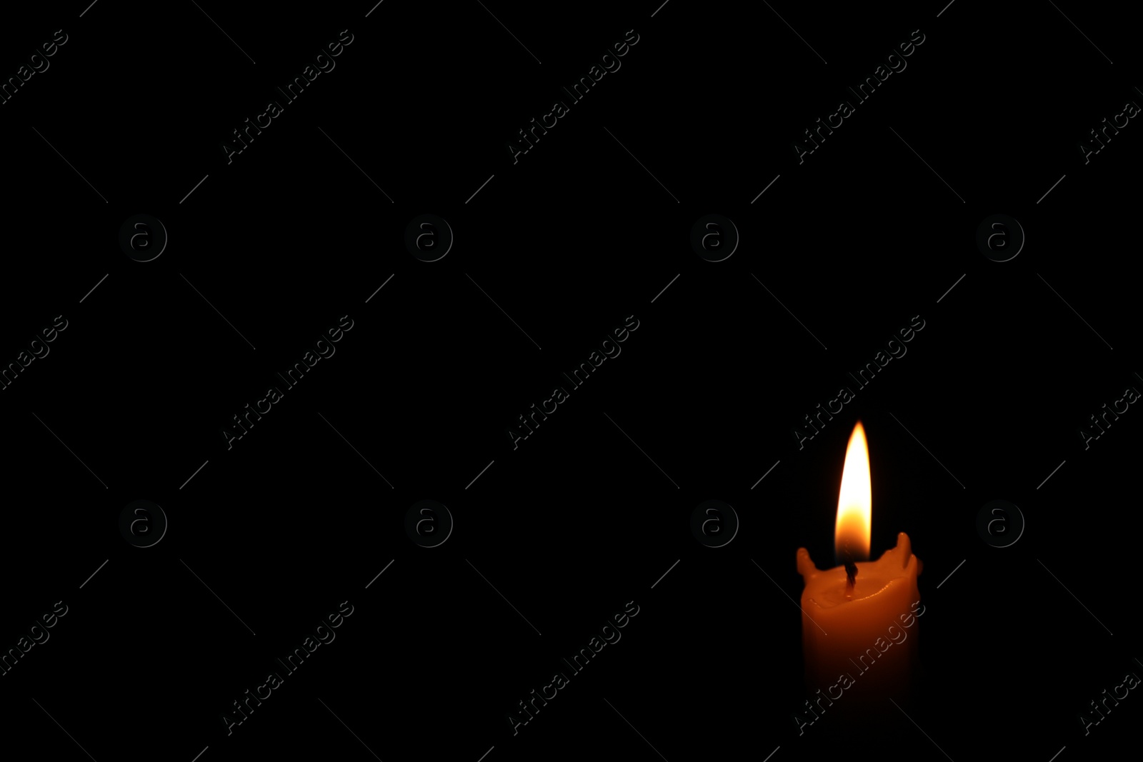 Photo of Burning wax candle in darkness. Space for text