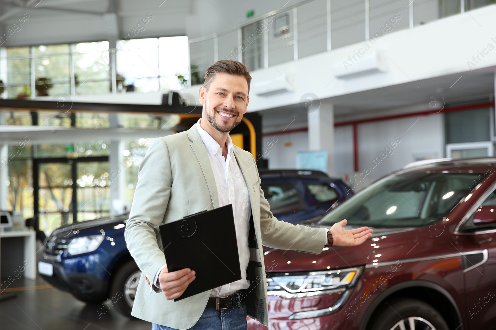 Photo of Salesman with clipboard in modern car dealership