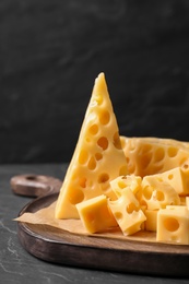 Photo of Tasty fresh cheese on dark grey table, closeup