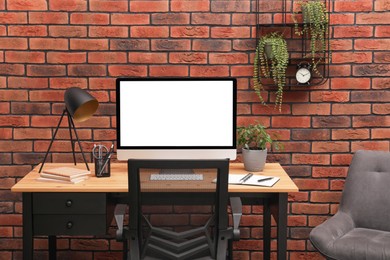 Photo of Cozy workplace with modern computer on desk and comfortable chair at home