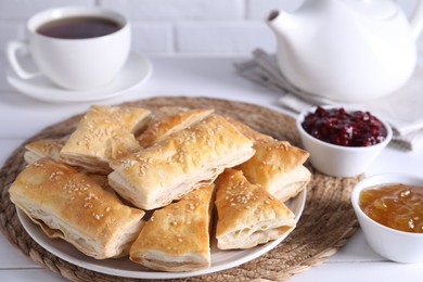 Photo of Delicious puff pastry served on white table, closeup