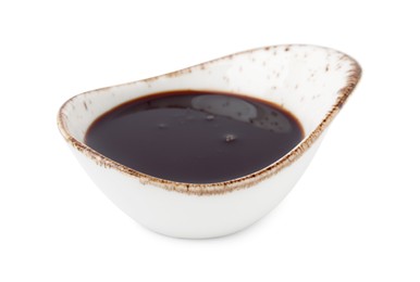 Photo of Tasty pomegranate sauce in gravy boat isolated on white