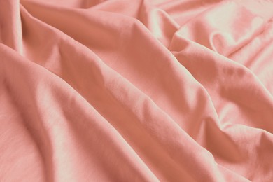 Pink shiny fabric as background, closeup view