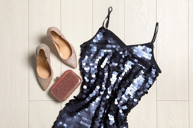 Stylish blue palette dress, bag and shoes on wooden floor, flat lay