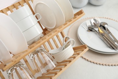 Photo of Drying rack with clean dishes on countertop in kitchen, closeup