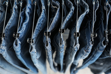 Photo of Hangers with stylish jeans on rack, above view