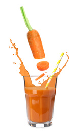 Image of Fresh cut carrot falling into glass of juice with splashes on white background