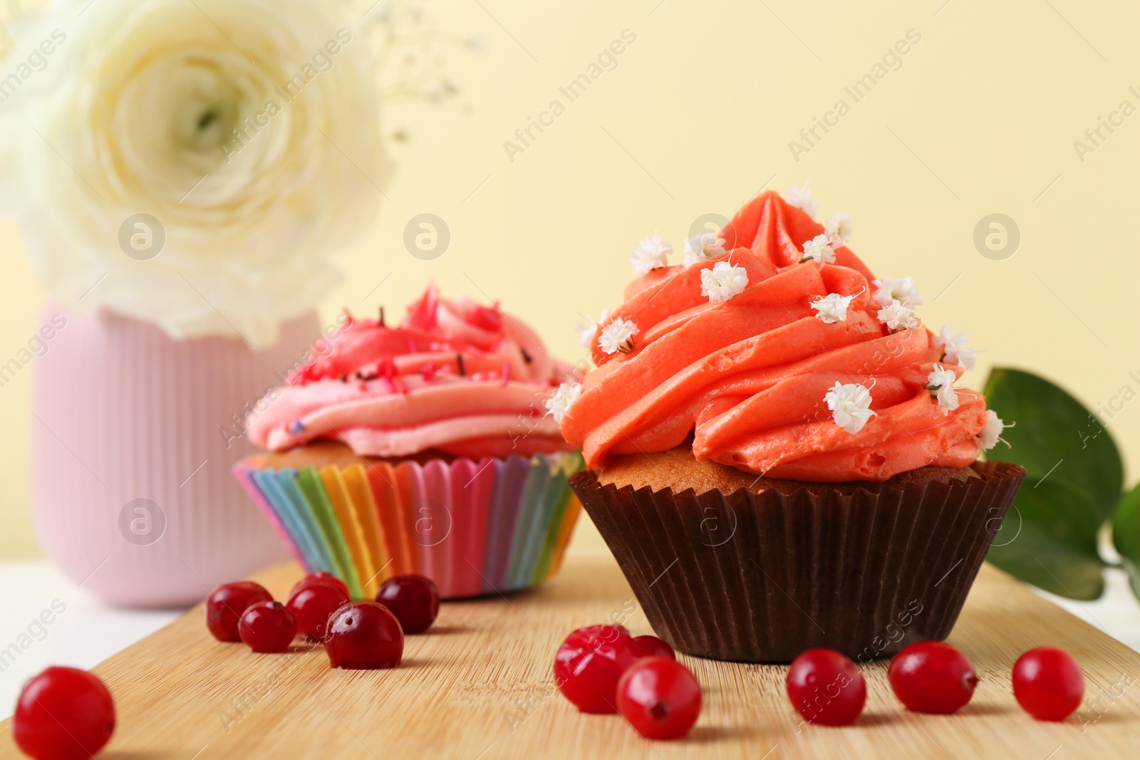 Photo of Delicious cupcake with bright cream and flowers on white table