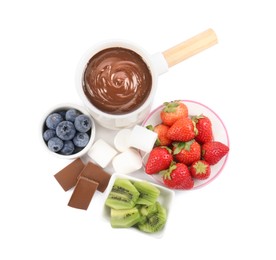 Photo of Fondue pot with melted chocolate, fresh berries, kiwi and marshmallows isolated on white, top view