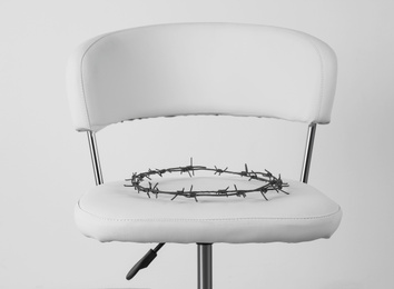 Photo of Chair with barbed wire on white background. Hemorrhoids concept
