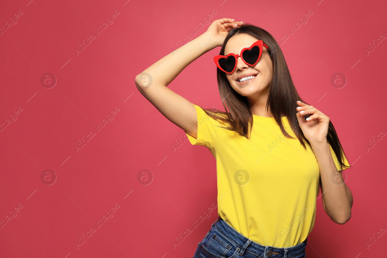 Photo of Portrait of beautiful young woman with heart shaped sunglasses on color background. Space for text