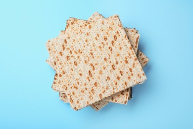 Photo of Stack of traditional matzos on light blue background, top view