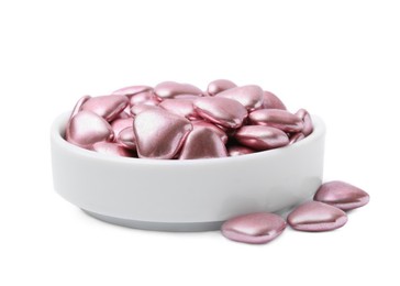 Bowl and delicious heart shaped candies on white background