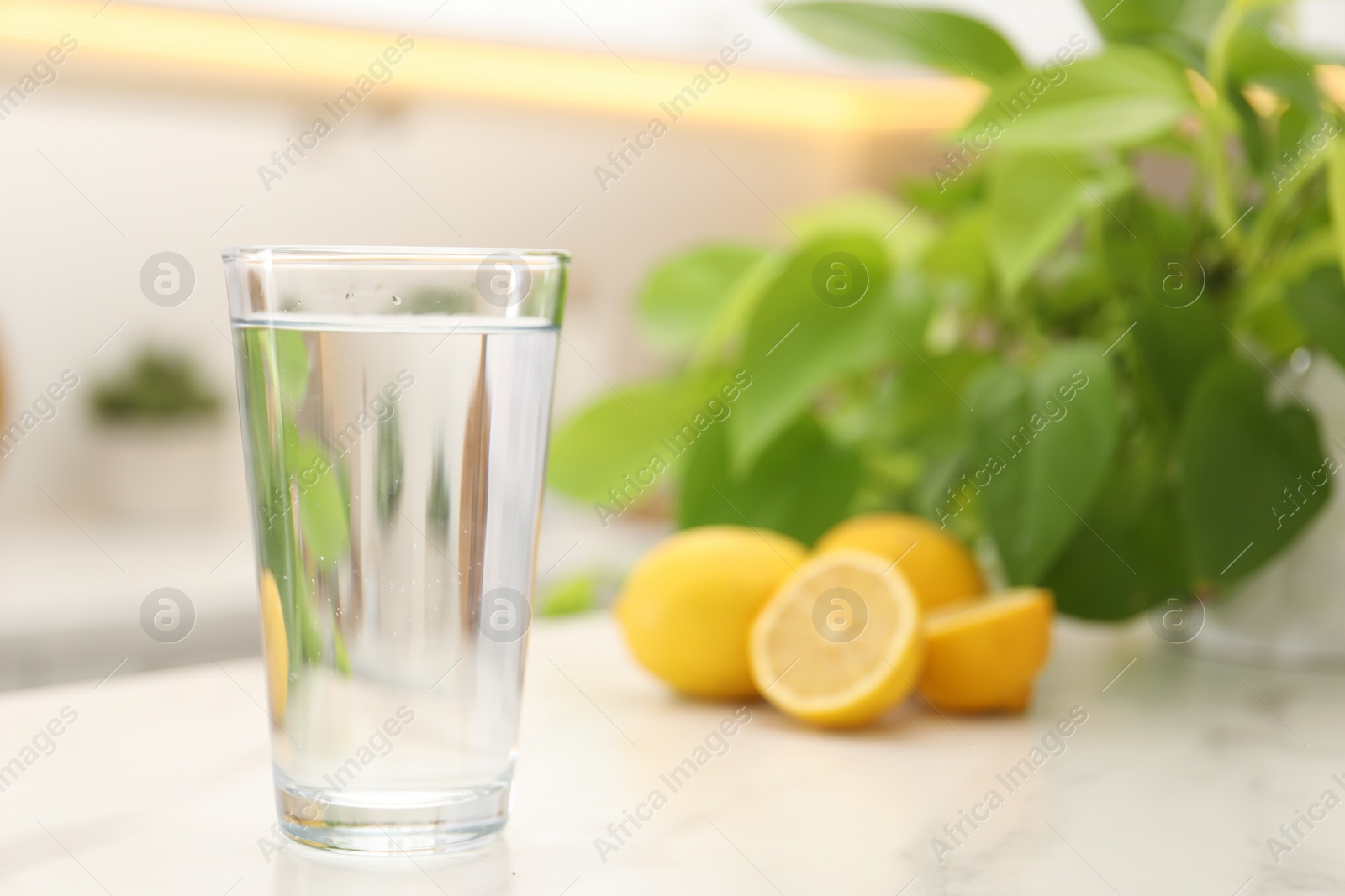 Photo of Glass with clear water on white table in kitchen