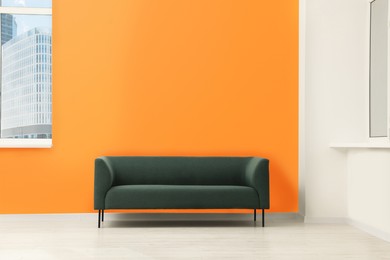 Beautiful interior with sofa near orange wall