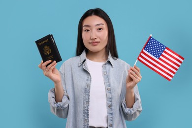 Immigration to United States of America. Woman with passport and flag on light blue background