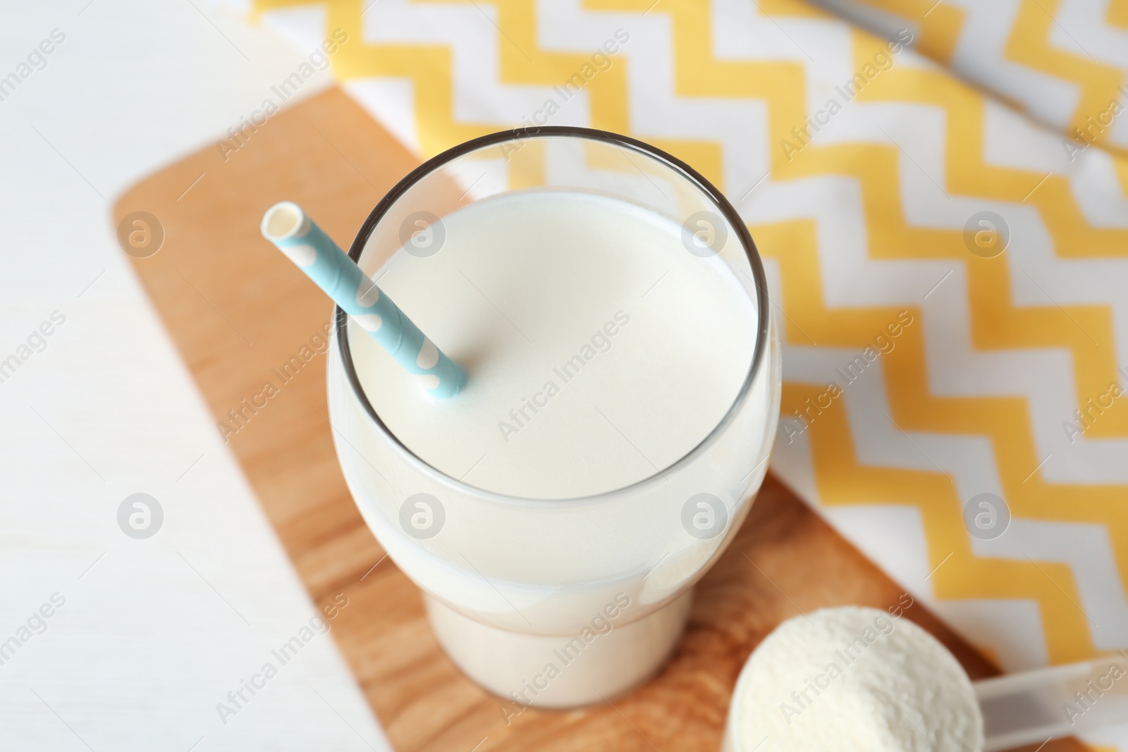 Photo of Protein shake in glass with straw on table, closeup