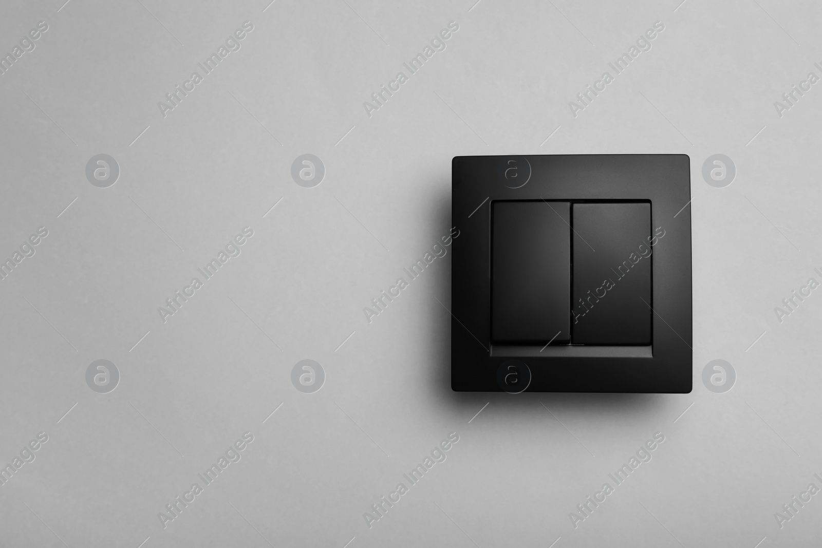 Photo of Modern plastic light switch on grey background. Space for text