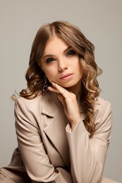 Portrait of young woman with beautiful makeup on grey background