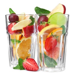 Photo of Different fruits in glasses on white background