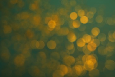 Photo of Blurred view of golden lights on green background. Bokeh effect