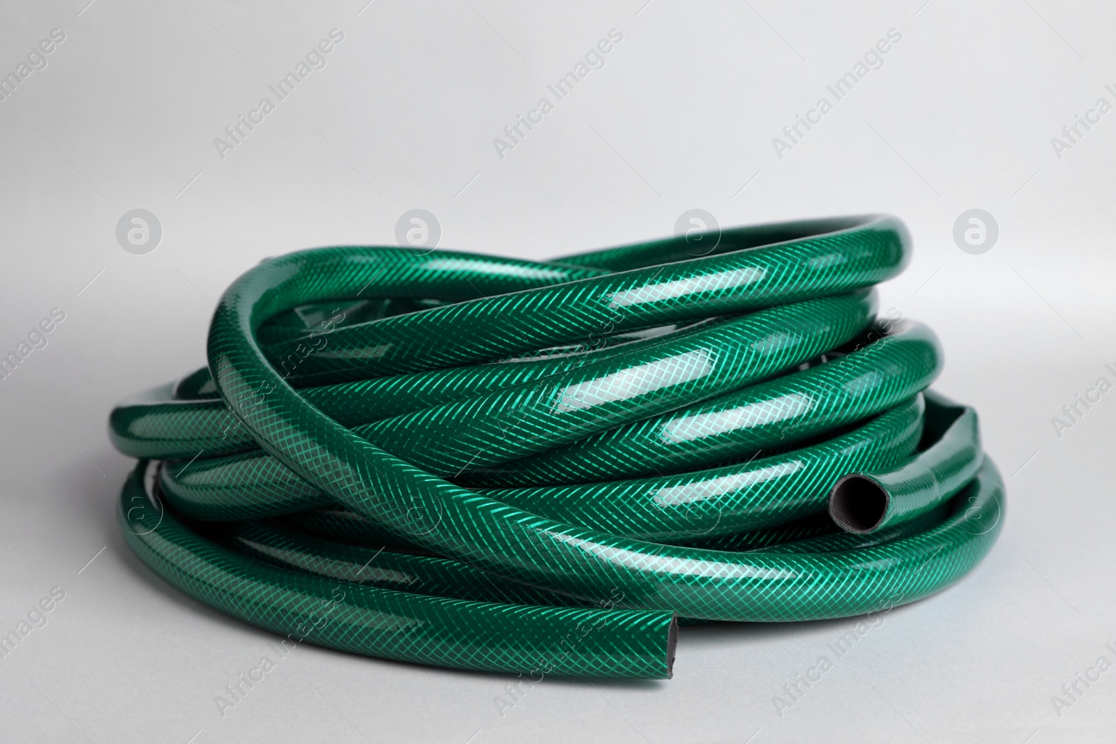 Photo of Watering hose on light grey background. Gardening tool