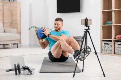 Trainer with ball streaming online workout on phone at home