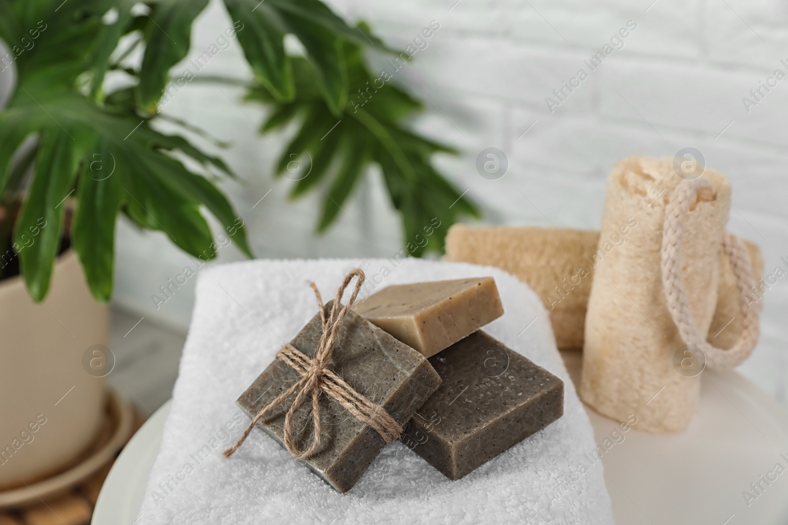 Photo of Handmade soap bars on white towel against blurred background