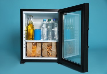 Mini bar filled with food and drinks on turquoise background