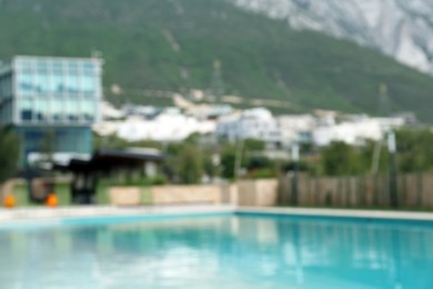 Photo of Outdoor swimming pool in inner yard of hotel, blurred view