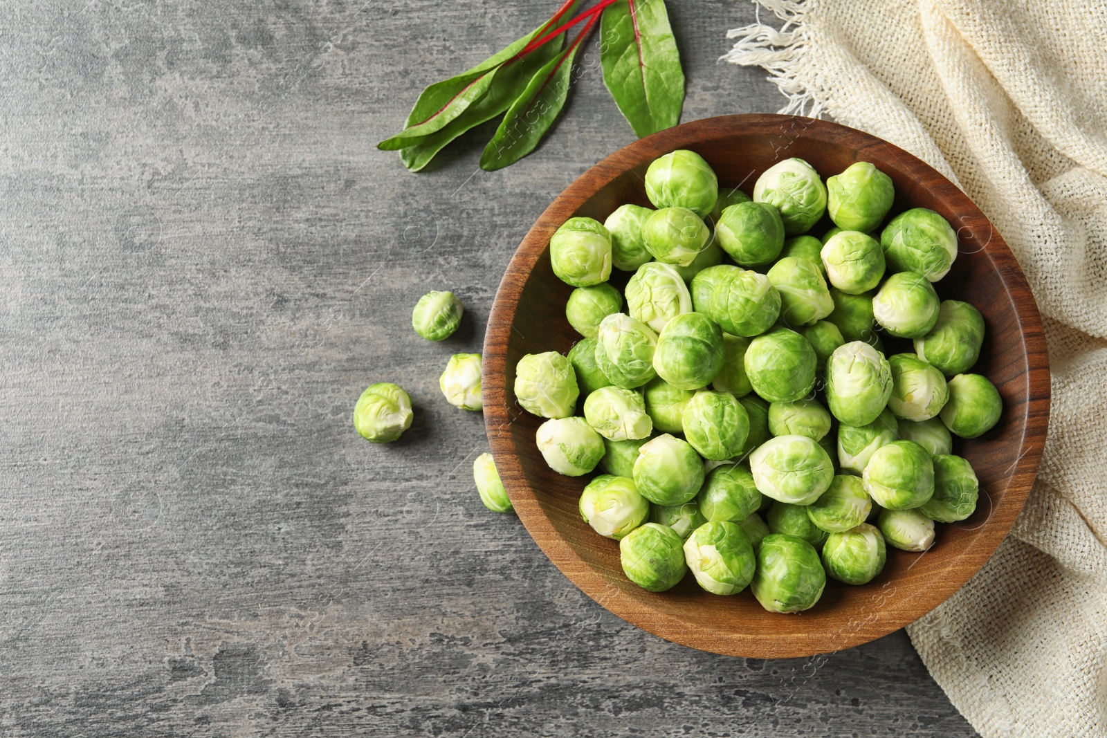 Photo of Flat lay composition with fresh Brussels sprouts and space for text on grey background