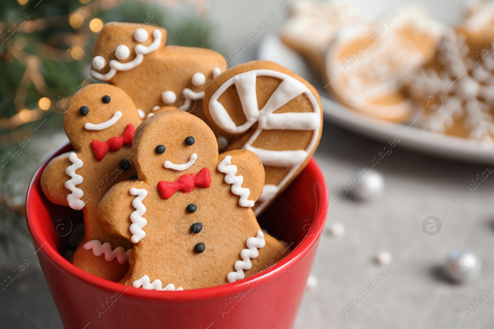 Photo of Tasty homemade Christmas cookies in cup on grey table, closeup view