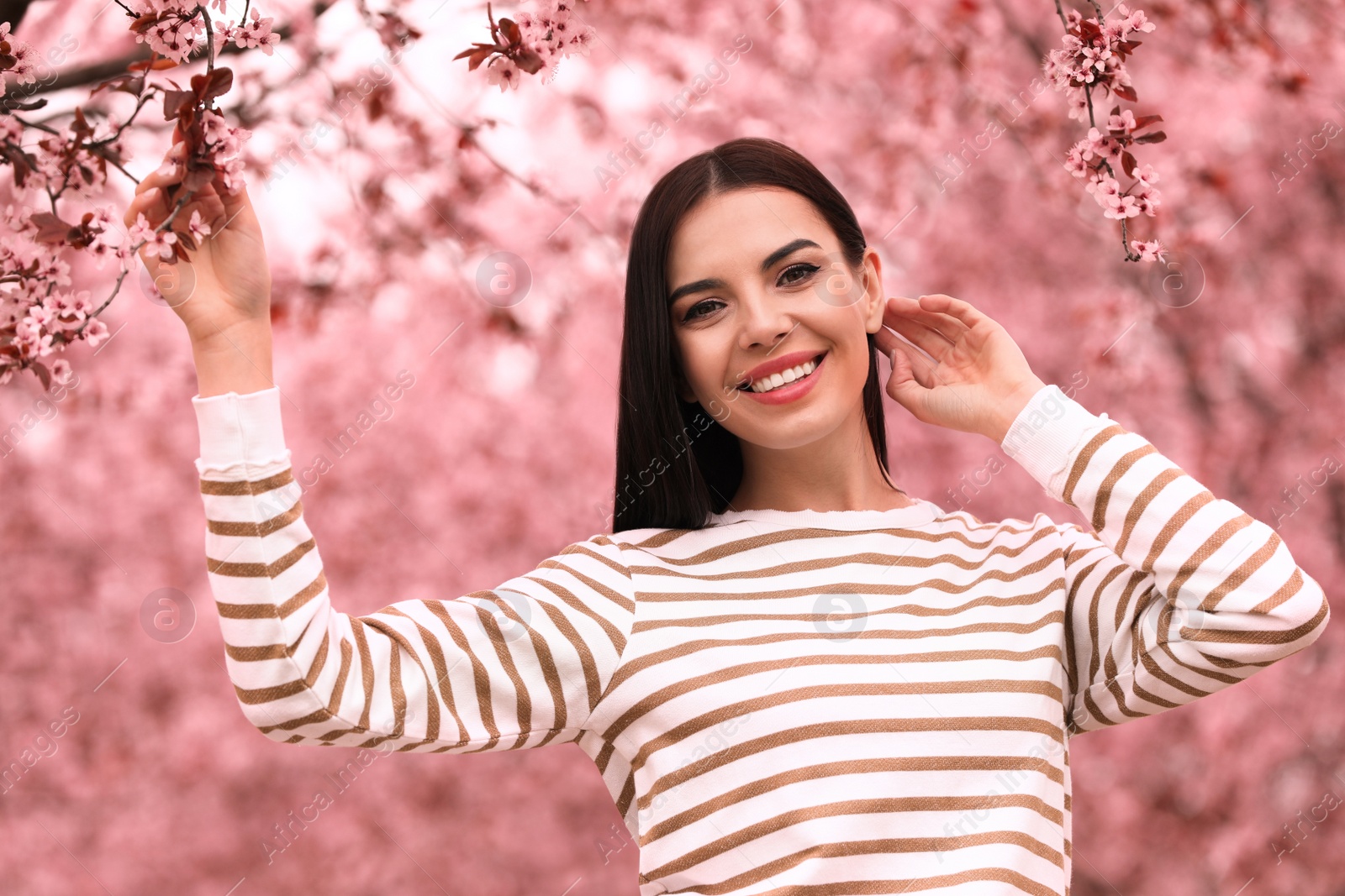 Photo of Pretty young woman in park with blooming trees. Spring look