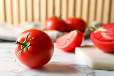 Photo of Fresh ripe tomatoes on white marble table, closeup