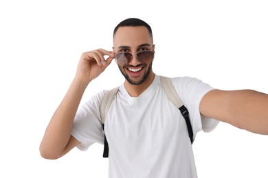 Smiling young man in sunglasses taking selfie on white background