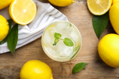 Cool freshly made lemonade and fruits on wooden table, flat lay