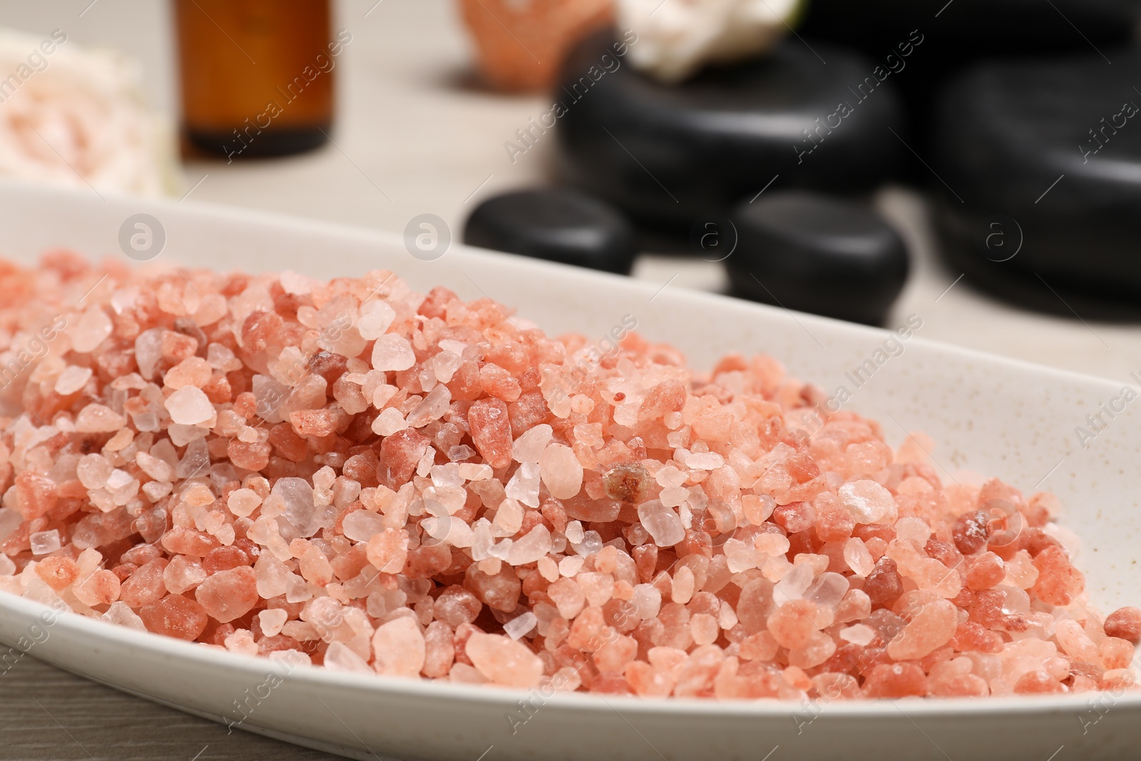 Photo of Natural sea salt in bowl on table, closeup