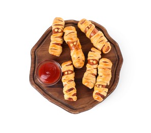 Cute sausage mummies served with ketchup isolated on white, top view. Halloween party food