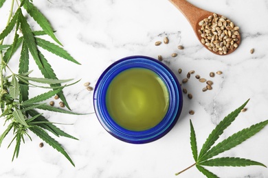 Photo of Jar of hemp cream and seeds on marble table, flat lay. Organic cosmetics