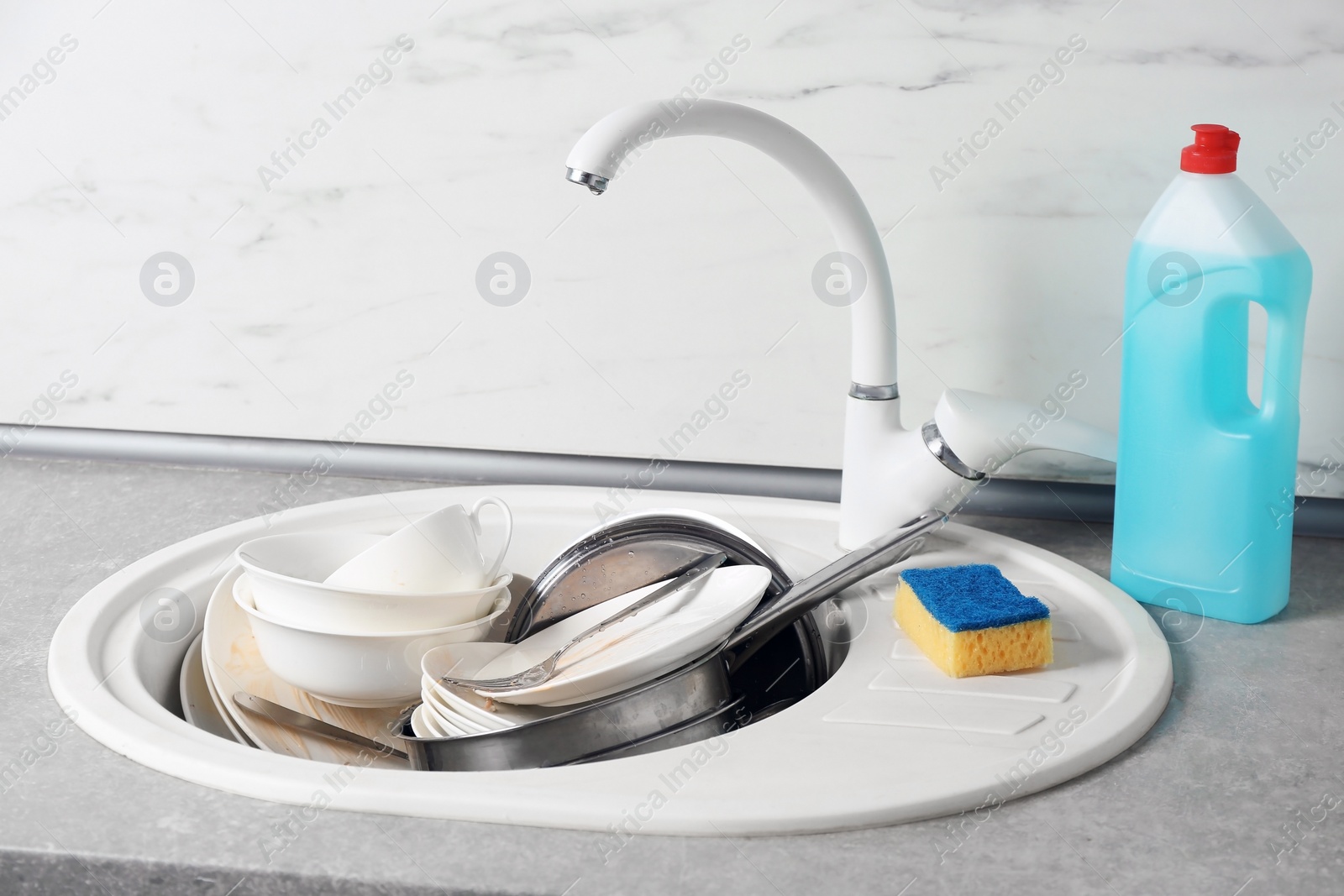 Photo of Messy pile of dirty dishes in sink