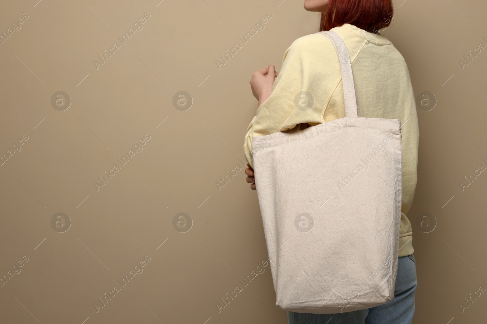 Photo of Woman with eco bag on beige background, closeup. Space for text