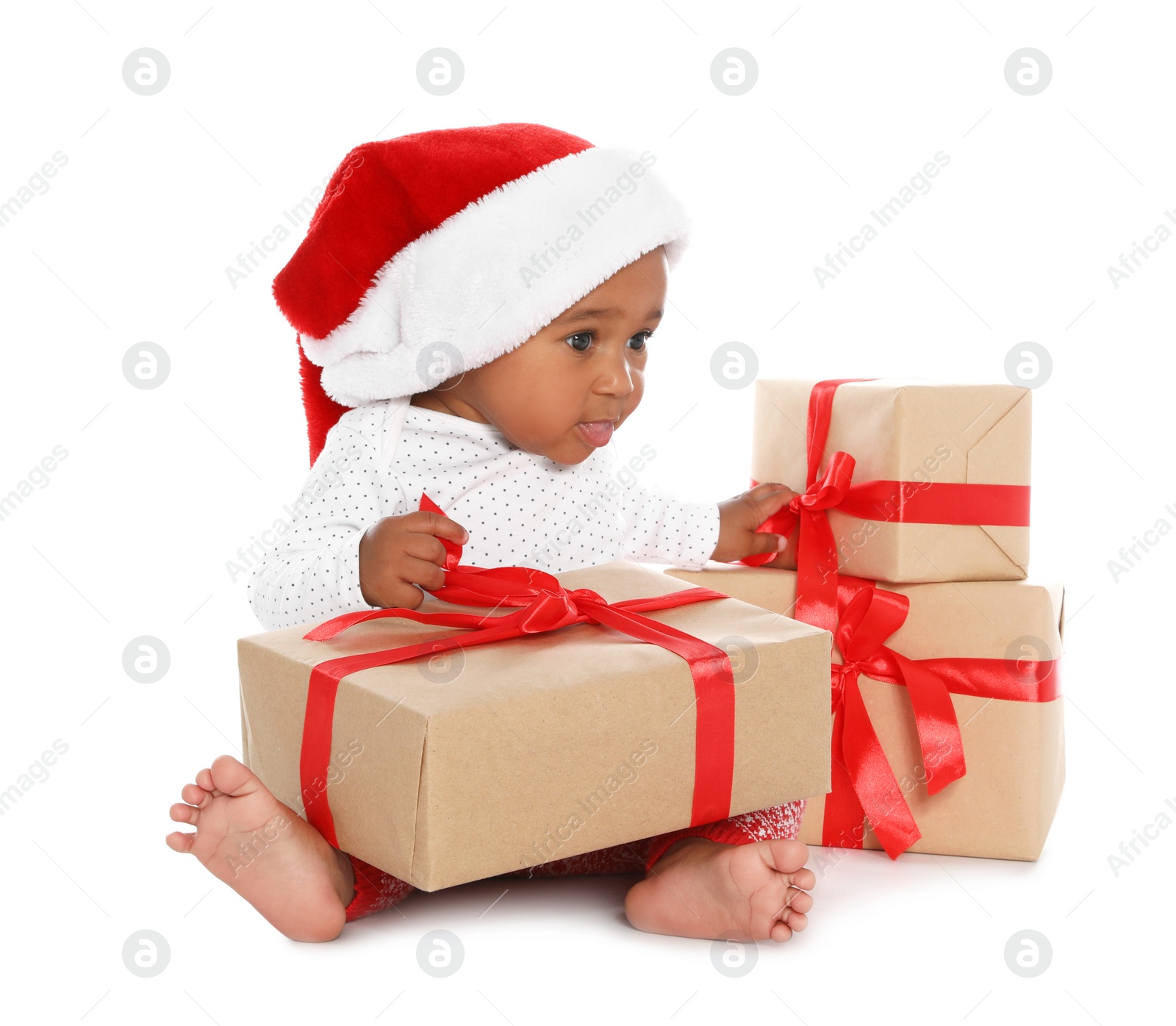Photo of Festively dressed African-American baby with Christmas gifts on white background