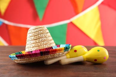 Mexican sombrero hat and maracas on wooden table