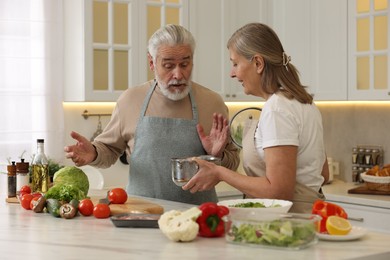 Photo of Lovely senior couple cooking together in kitchen